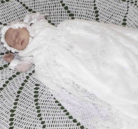 A beautiful unisex christening gown displayed on a neutral background.